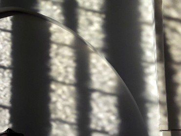 Schatten von Fensterstreben auf einer Wand.