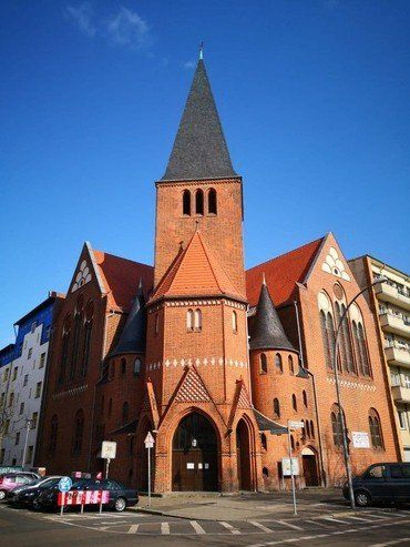 Außenansicht der Adventkirche in Berlin unter klarem Himmel.