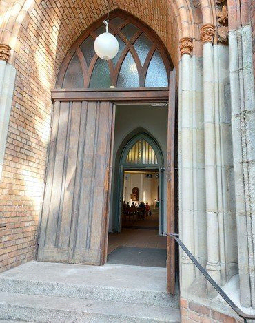 Offene Holztür einer Kirche.